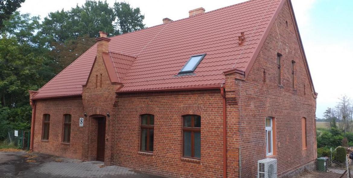 Świetlica w Przyłubiu - dom z czerwonej cegły, dach pokryty nową dachówką.