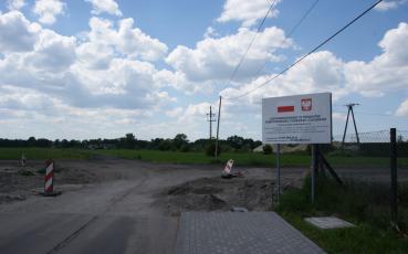 Widok na ulicę Łąkową. Po prawej stronie tablica o dofinansowaniu.