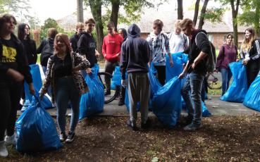 Uczniowie w czasie sprzątania z napełnionymi workami na śmieci.