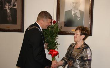 Burmistrz otrzymuje kwiaty i gratulacje od przewodniczącego rady.