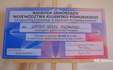 Czek z tworzywa na drewnianej sztaludze.