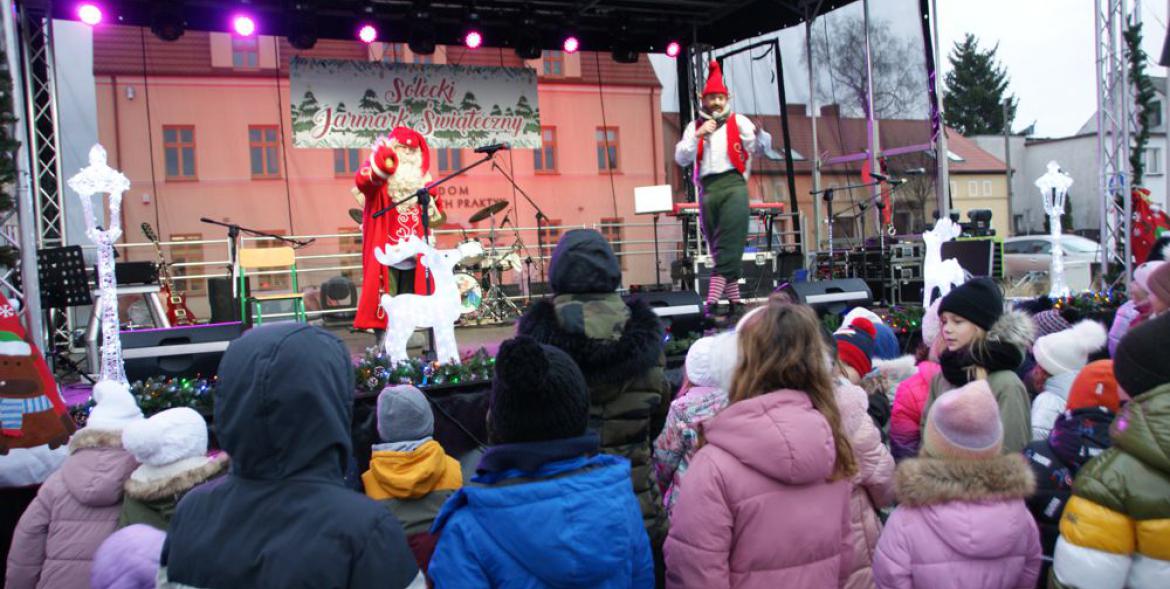 Na scenie święty Mikołaj z Elfem, przed nią dziecięca publiczność.