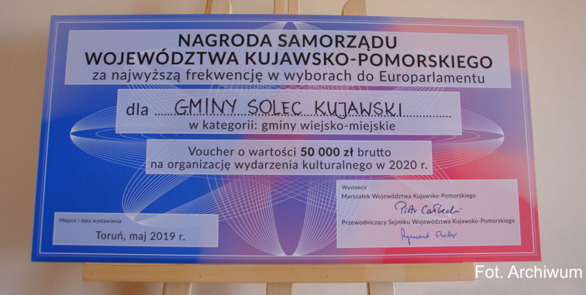 Czek z tworzywa na drewnianej sztaludze.