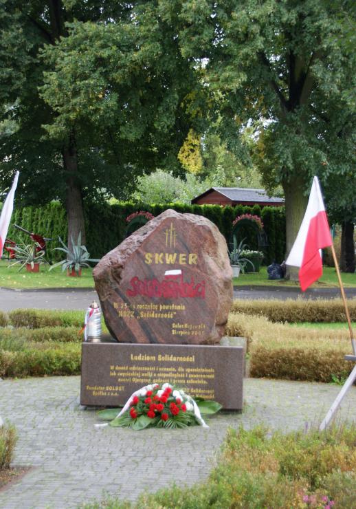 Obelisk. Obok flagi biało-czerone i NSZZ Solidarność.